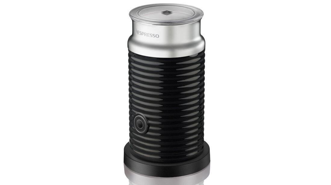 Czarny spieniacz do mleka z metalicznym wieczkiem i logo \'NESPRESSO\'. Urządzenie ma żebrowaną powierzchnię i okrągły przycisk na korpusie.