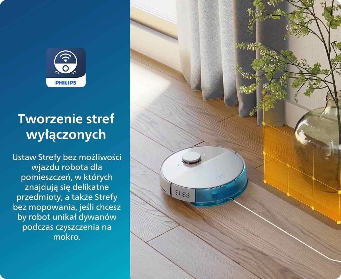 Obraz przedstawia robot sprzątający na drewnianej podłodze obok zasłony i rośliny w wazonie. Po lewej stronie znajduje się tekst: \'Tworzenie stref wyłączonych Ustaw Strefy bez możliwości wjazdu robota dla pomieszczeń, w których znajdują się delikatne przedmioty, a także Strefy bez mopowania, jeśli chcesz by robot unikał dywanów podczas czyszczenia na mokro.\'