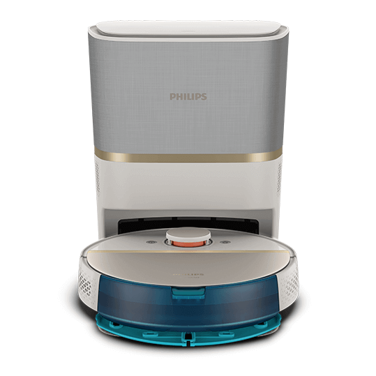Robot sprzątający z okrągłą, płaską konstrukcją w kolorze białym i niebieskim, przed stacją dokującą. Na stacji widoczne jest logo \'PHILIPS\'.