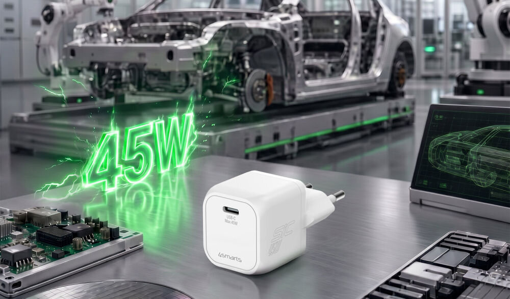 Biała ładowarka USB-C z logo \'4smarts\' leży na metalowym stole w otoczeniu elementów elektronicznych i części samochodowych. W tle widoczny jest napis \'45W\' w zielonym kolorze oraz zarys samochodu na ekranie.
