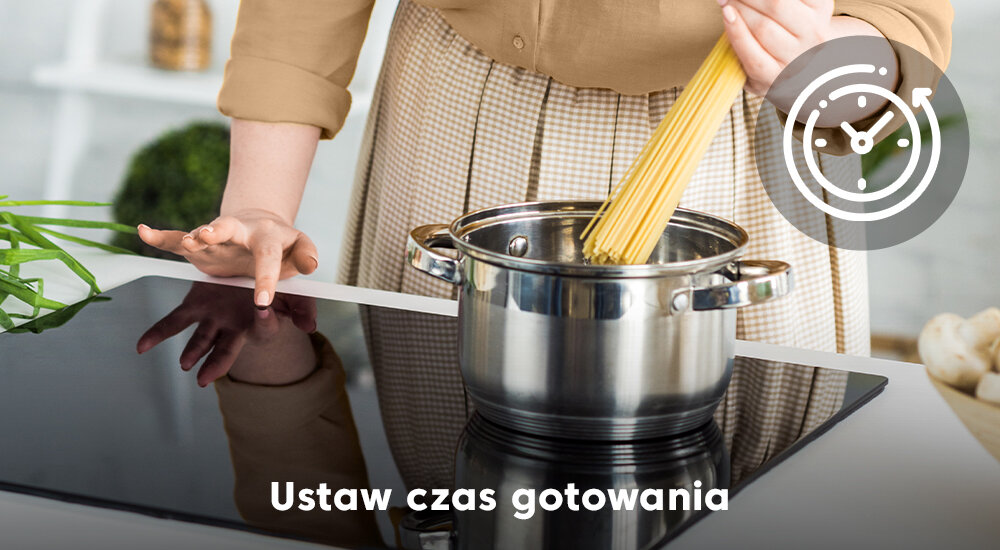 Osoba wkłada makaron do garnka stojącego na płycie indukcyjnej. Na obrazie widoczny jest tekst: \'Ustaw czas gotowania\'.