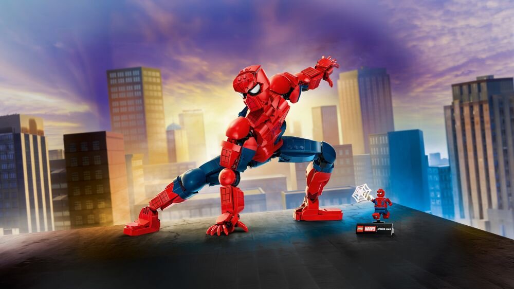 Na tle miejskiego krajobrazu znajduje się duża figurka Spider-Mana w dynamicznej pozie oraz mniejsza figurka z logo Marvel i media expert.