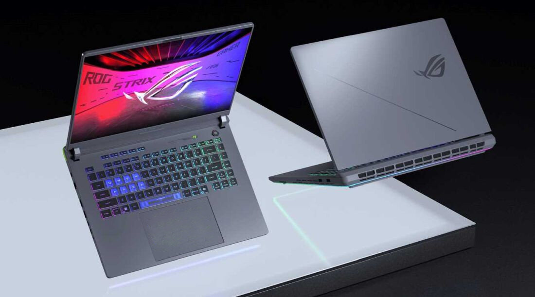 Na obrazie widoczne są dwa laptopy z logo ROG, jeden otwarty z podświetlaną klawiaturą, drugi zamknięty z widocznym logo na obudowie. Ekran otwartego laptopa wyświetla grafikę z napisem \'ROG STRIX\'.