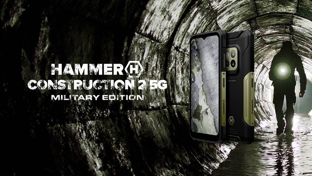 Obraz przedstawia smartfon w ochronnym etui na tle tunelu z osobą trzymającą latarkę. Widoczny tekst: \'HAMMER CONSTRUCTION 2 5G MILITARY EDITION\'.