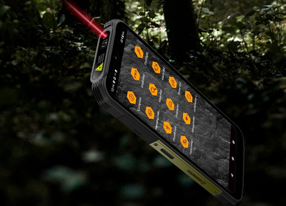 Smartfon z wyświetlaczem pokazującym aplikacje w pomarańczowych ikonach na tle lasu. Na obudowie widoczny jest napis \'HAMMER\'.