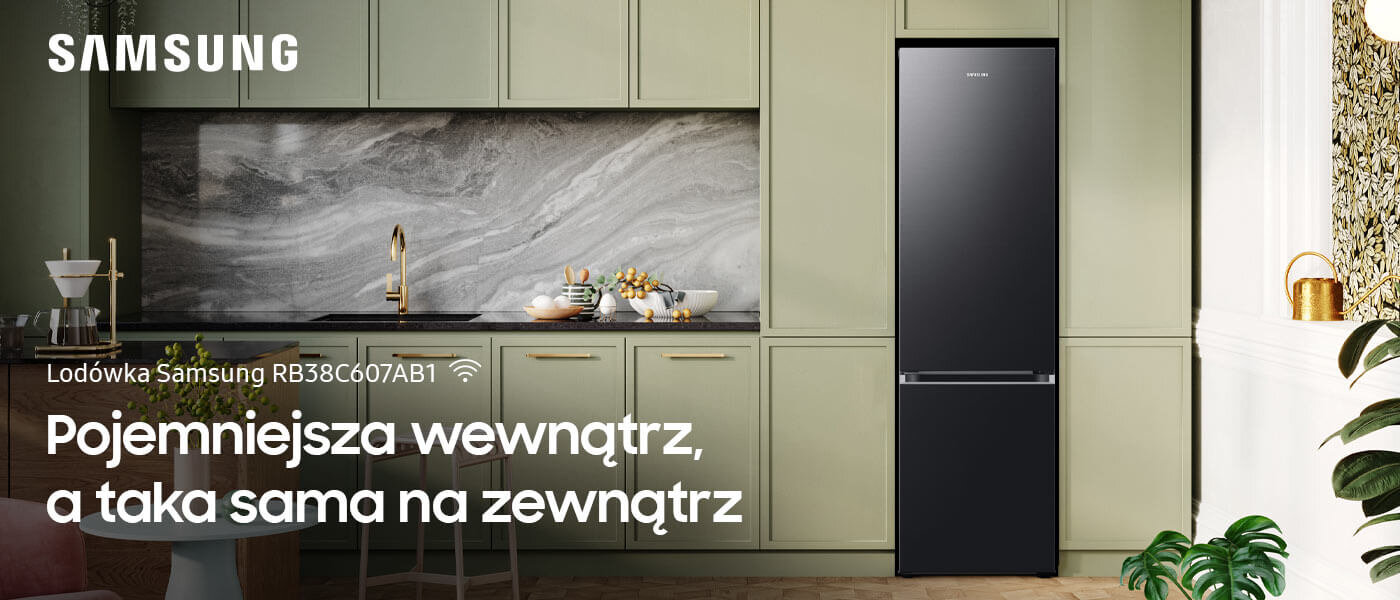 Media Expert - lodówka Samsung RB38C607AB1 w ciemnozielonym pomieszczeniu Kuchnia z lodówką w grafitowym kolorze, obok szafek w jasnym odcieniu. Na obrazie widoczny jest tekst: \'Lodówka Samsung RB38C607AB1 Pojemniejsza wewnątrz, a taka sama na zewnątrz\'.