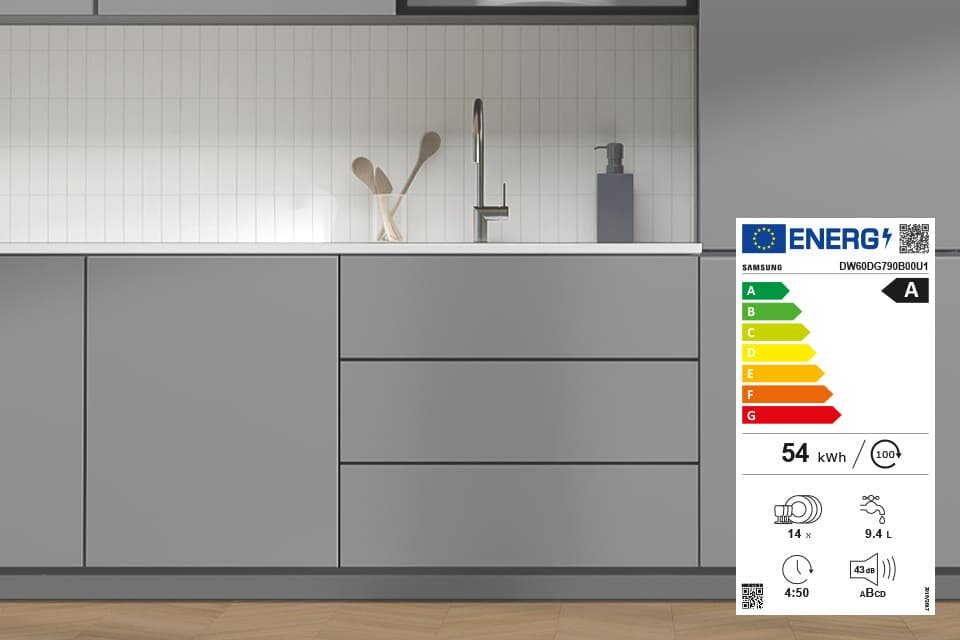 energooszczędna zmywarka dw60dg790b00u1 w najwyższej klasie energetycznej Szara kuchnia z szafkami i zlewem, obok widoczna etykieta energetyczna zmywarki SAMSUNG DW60DG790B00U1 z klasą A, zużyciem 54 kWh i pojemnością 14 kompletów naczyń.