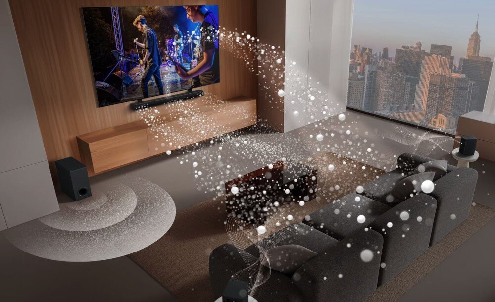 W nowoczesnym salonie znajduje się telewizor z wyświetlanym koncertem oraz soundbar z subwooferem. Widać wizualizację dźwięku rozchodzącego się po pomieszczeniu, a za oknem rozciąga się panorama miasta.