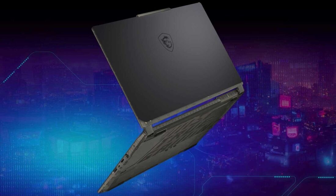 Laptop z widocznym logo producenta na pokrywie, ustawiony pod kątem na tle futurystycznego miasta z neonowymi światłami.