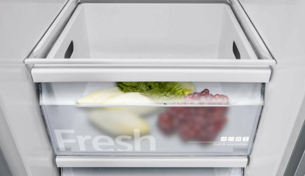 Wnętrze szuflady lodówki z napisem \'Fresh\', zawierające sałatę i winogrona. Szuflada jest przezroczysta, z widocznymi napisami \'fruit & vegetables\'.