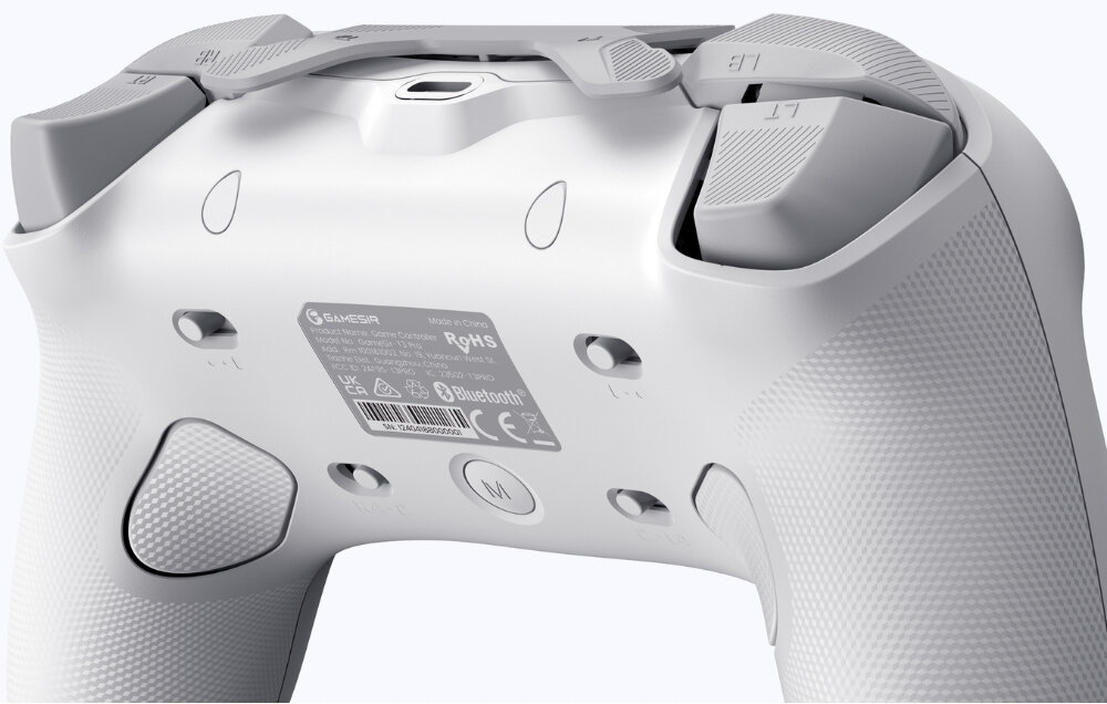 Biały kontroler z widocznymi przyciskami i teksturą uchwytów. Na spodzie znajduje się etykieta z logo \'GAMESIR\' oraz informacjami technicznymi i certyfikatami.