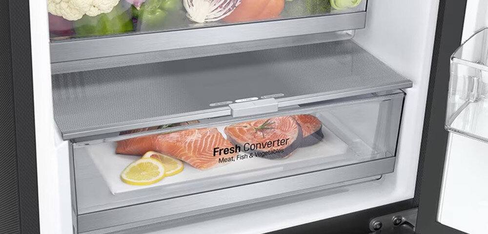 Wnętrze lodówki z widoczną szufladą oznaczoną napisem \'Fresh Converter Meat, Fish & Vegetables\', w której znajduje się łosoś i plasterki cytryny.