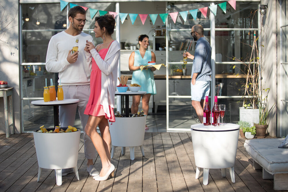 Barek ogrodowy KETER Cool 17186745 Szaro-biały stolik w trzech ujęciach na tarasie taras wypełniony ludźmi na blatach butelki przekąski i kieliszki praktyczny pomocnik wielofunkcyjne rozwiązanie chłodzenie stolik kawowy barek na napoje