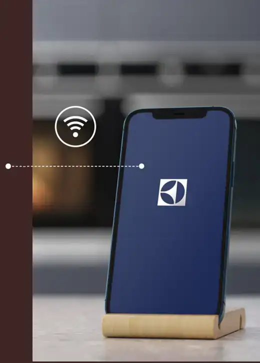 Smartfon na stojaku z wyświetlonym logo Electrolux na ekranie. Obok znajduje się ikona sygnału Wi-Fi połączona linią z telefonem.