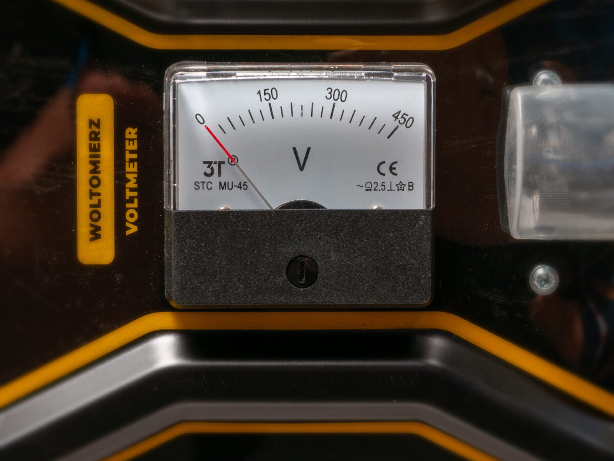 Zdjęcie przedstawia woltomierz z oznaczeniami \'WOLTOMIERZ VOLTMETER\' oraz skalą od 0 do 450 V. Na tarczy widoczne są również oznaczenia \'STC MU-45\' i \'CE ~2.5 L B\'.