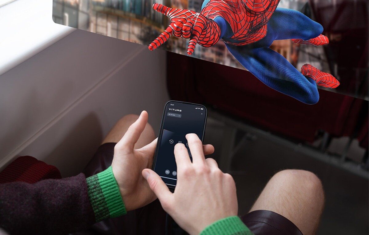 Sekcja o integracji ze środowiskiem iOS: Osoba steruje aplikacją Viture na smartfonie podczas oglądania filmu z trójwymiarową grafiką SpiderMan'a.