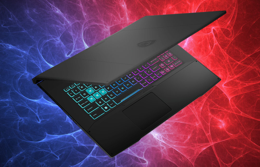Laptop z podświetlaną klawiaturą w kolorach tęczy, częściowo otwarty, na tle niebiesko-czerwonych wzorów. Na obudowie widoczne jest logo producenta.