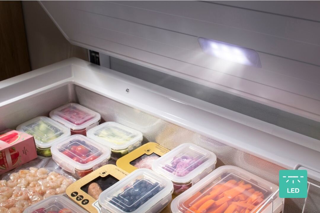 ZAMRAŻARKA GORENJE FH30EAW Otwarte wnętrze zamrażarki z pojemnikami na żywność i produktami mrożonymi. W górnej części widoczne jest oświetlenie LED oraz ikona „LED” oświetlenie LED jasne wnętrze niski pobór energii długa żywotność