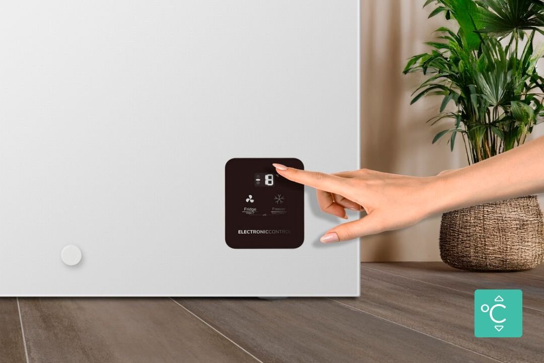 ZAMRAŻARKA GORENJE FH30EAW Dłoń dotyka panelu sterowania zamrażarki z wyświetlaczem temperatury. W prawym dolnym rogu widoczna jest ikona termometru sterowanie elektroniczne wyświetlacz LED kontrola temperatury wygodny panel