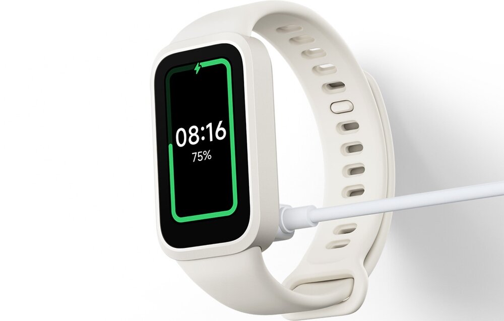 Beżowo-biały smartband z prostokątnym ekranem, na którym wyświetlany jest czas 08:16 i poziom naładowania 75%. Urządzenie jest podłączone do ładowarki.