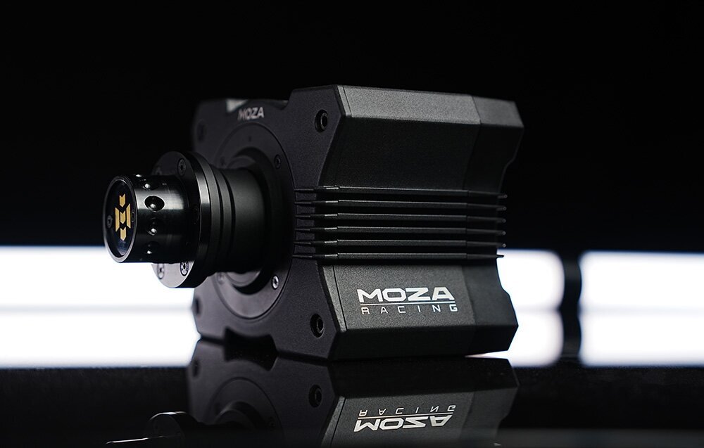 Na obrazie widoczna jest czarna kierownica symulacyjna z logo MOZA Racing, umieszczona na ciemnym tle z jasnymi, poziomymi liniami w tle. Produkt ma nowoczesny design z wyraźnymi żebrowaniami na obudowie.