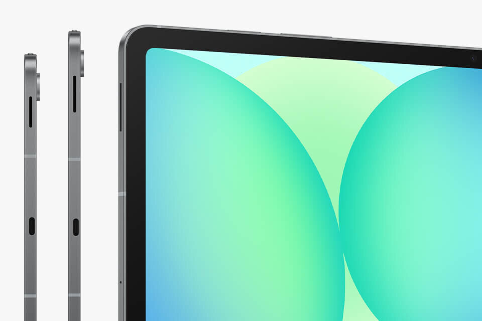 Obraz przedstawia tablet z widocznym ekranem o jasnym, kolorowym tle oraz bocznym widokiem urządzenia z metaliczną obudową. Na ekranie widoczne są duże, zielono-niebieskie okręgi.