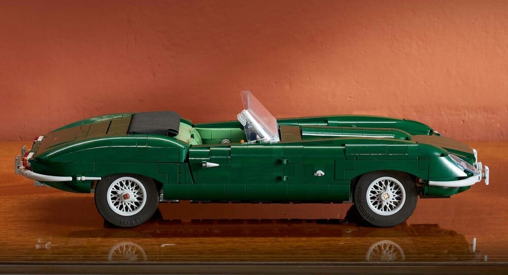 Model samochodu z klocków LEGO w kolorze zielonym, przedstawiający klasyczny kabriolet. Samochód ma szczegółowe elementy, takie jak koła z szprychami i przezroczystą szybę przednią.
