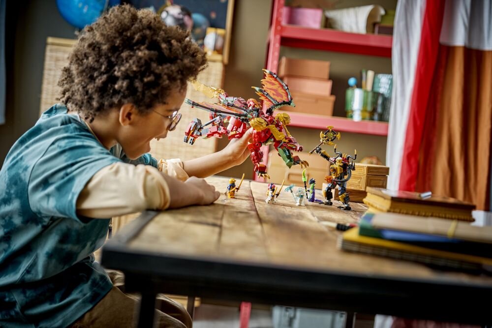 Dziecko bawi się zestawem LEGO przedstawiającym smoczego mecha na drewnianym stole. W tle widać półki z różnymi przedmiotami.