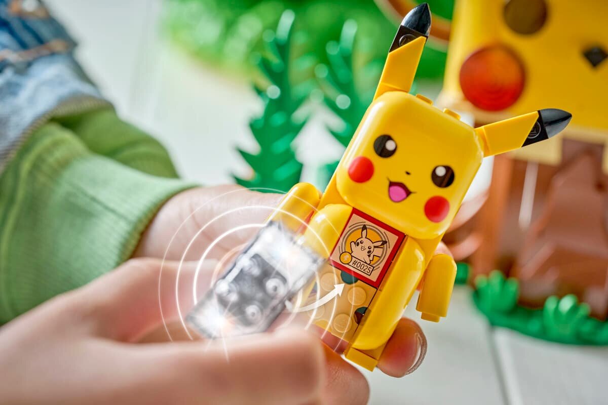 Na zdjęciu widać figurkę Pikachu z klocków, trzymaną w dłoni. Na brzuchu figurki znajduje się obrazek z napisem \'HO025\'.