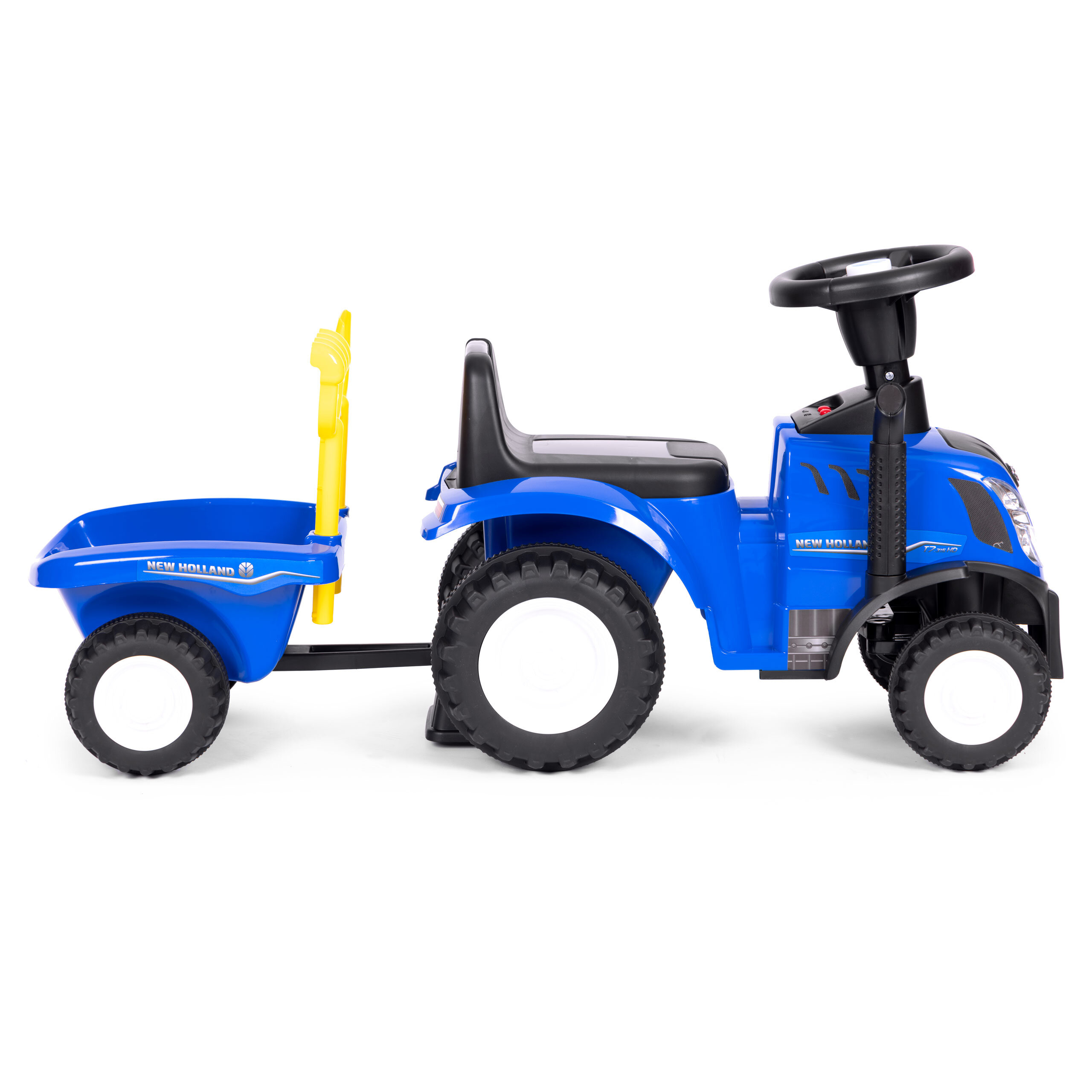 Niebieski jeździk w kształcie traktora z przyczepką, posiada interaktywną kierownicę i czarne koła. Na przyczepce widoczny jest napis \'NEW HOLLAND\'.