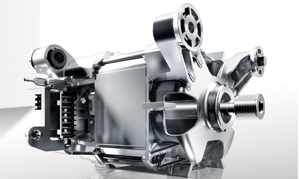Obraz przedstawia metalowy element mechaniczny o skomplikowanej konstrukcji, z widocznymi śrubami i zębatkami. Element jest wykonany z błyszczącego metalu i ma industrialny wygląd.
