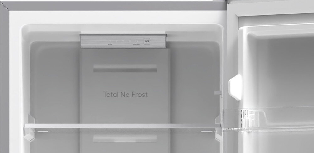 Wnętrze lodówki z widoczną półką i napisem \'Total No Frost\'.