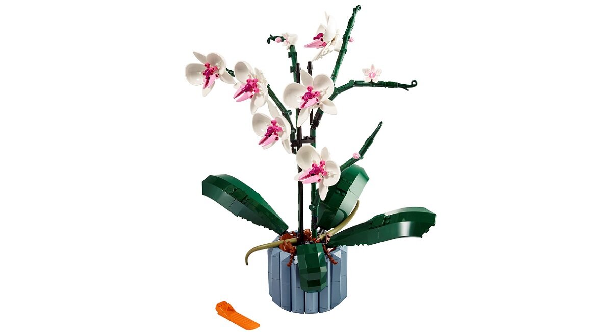 Model orchidei z klocków LEGO w doniczce, z białymi i różowymi kwiatami oraz zielonymi liśćmi. Obok znajduje się pomarańczowy element przypominający narzędzie.