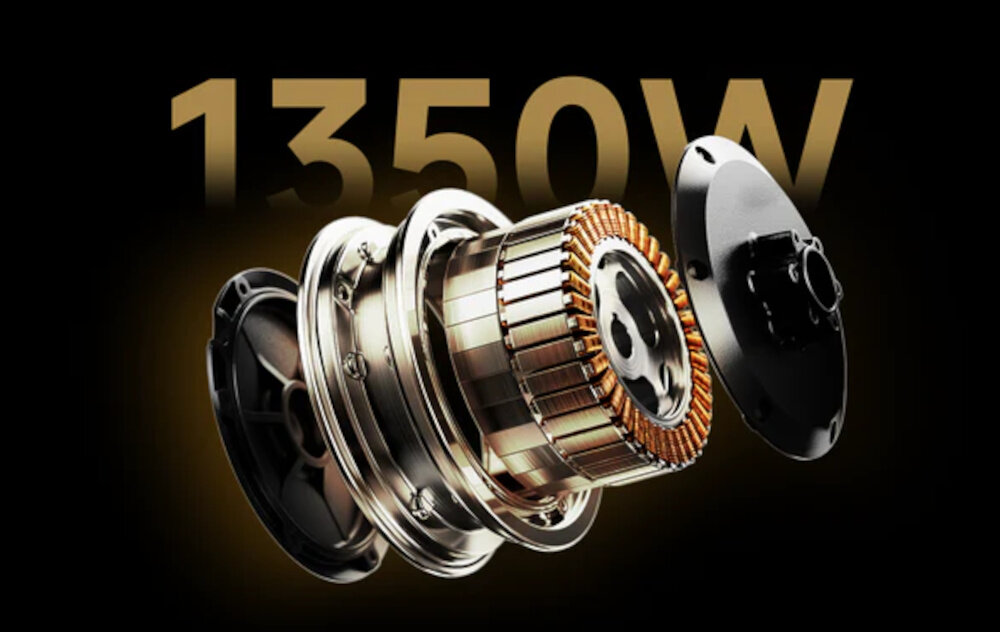 Obraz przedstawia element mechaniczny z widocznymi zwojami i metalowymi częściami. W tle znajduje się napis \'1350W\'.