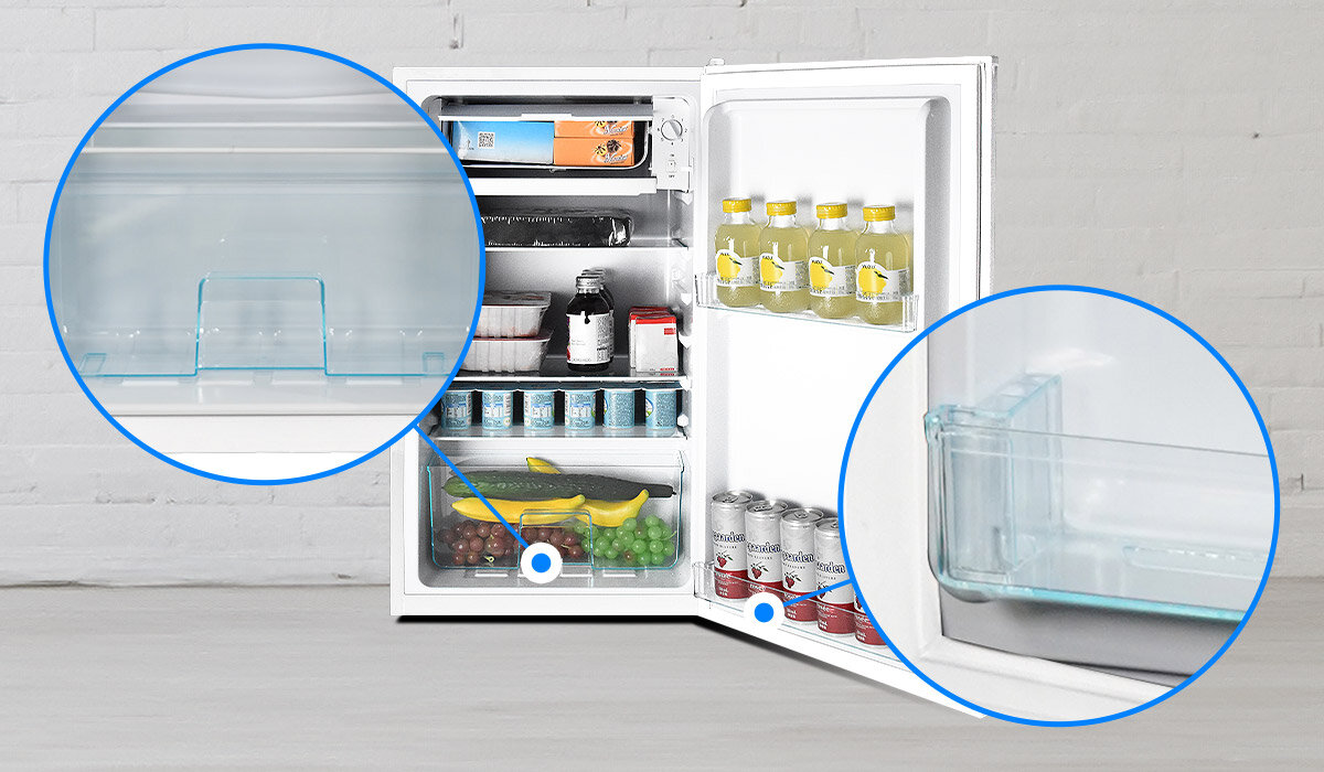 Otwarta biała lodówka z widocznymi półkami wypełnionymi różnymi produktami spożywczymi, takimi jak napoje, owoce i puszki. Dwa powiększone okręgi pokazują szczegóły wnętrza lodówki, w tym przezroczyste półki.