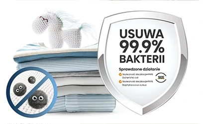 Stos ubrań z pluszowym jednorożcem na górze oraz tarcza z napisem \'USUWA 99.9% BAKTERII\'. Obok znajduje się symbol przekreślonych bakterii i lista \'Sprawdzone działanie\'.