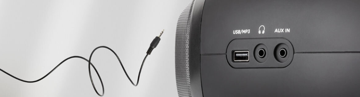 Zbliżenie na panel boczny urządzenia z portami USB/MP3, słuchawkowym i AUX IN oraz wtyczką jack na kablu.