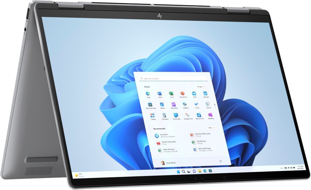 Laptop w trybie namiotu z widocznym ekranem startowym systemu Windows 11. Na ekranie wyświetlone są ikony aplikacji oraz pasek zadań.