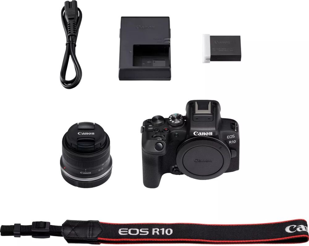 Na obrazie znajduje się aparat bezlusterkowy Canon EOS R10 z obiektywem, ładowarka, bateria, kabel zasilający oraz pasek z napisem \'EOS R10\'. Widoczne jest logo \'Canon\' na aparacie i obiektywie.