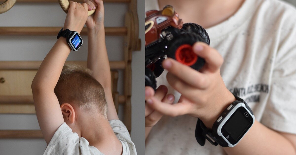 Dziecko nosi czarny smartwatch na nadgarstku, bawiąc się zabawkowym samochodem. Smartwatch ma prostokątny ekran z widocznym interfejsem.