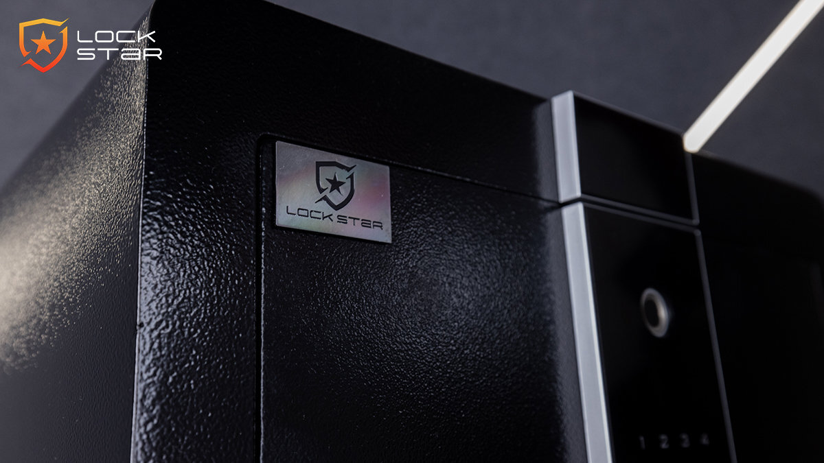 Czarny sejf z elektronicznym panelem i logo \'LOCK STAR\' na metalowej tabliczce. Widoczny jest panel z przyciskami numerycznymi i otworem na klucz.