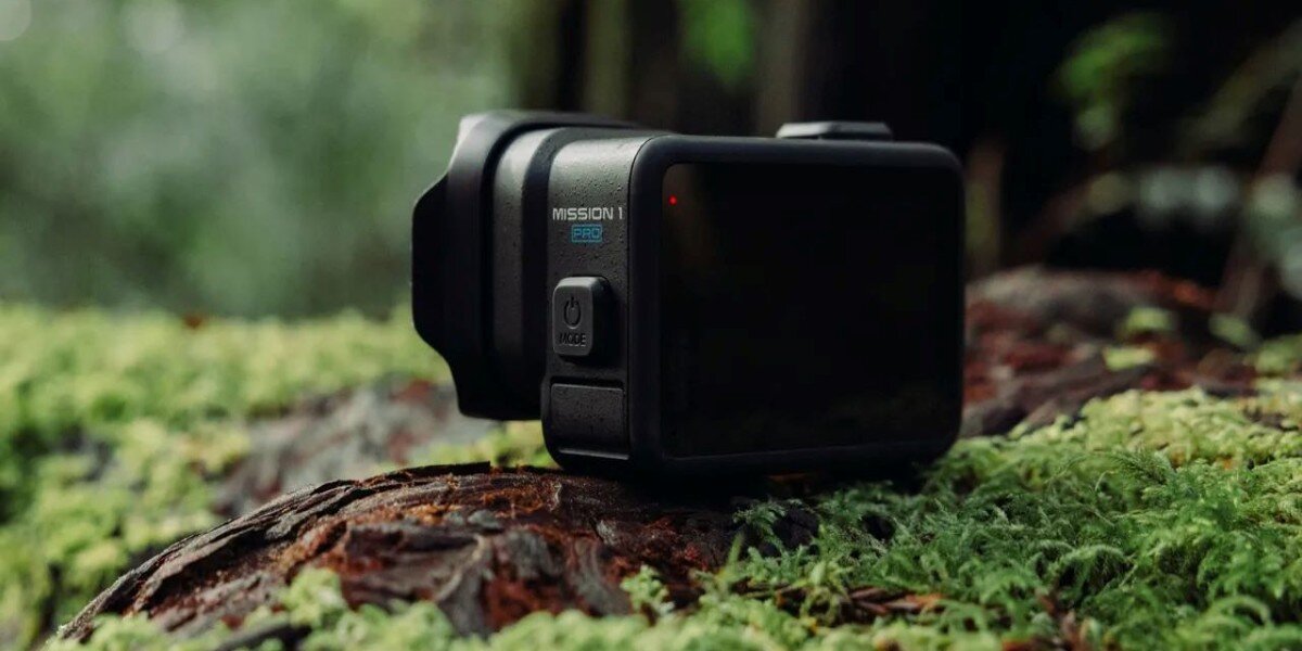 Kamera GOPRO Mission 1 Pro leżąca na mchu przy ściółce leśnej.