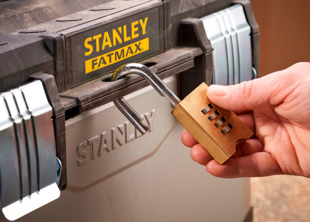 Skrzynia narzędziowa STANLEY Fatmax 1-95-617 zbliżenie na otwór do kłódki osoba zakłada kłódkę na skrzynię otwór umożliwiający założenie kłódki bezpieczeństwo przechowywanych narzędzi