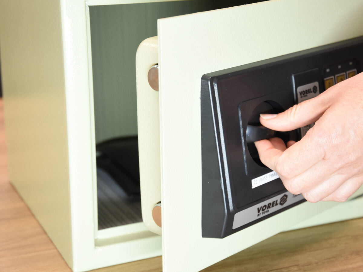 Sejf VOREL 78642, Obudowa, grubość, trwałość, odporność, dłoń trzyma pokrętło sejfu z otwartymi drzwiczkami