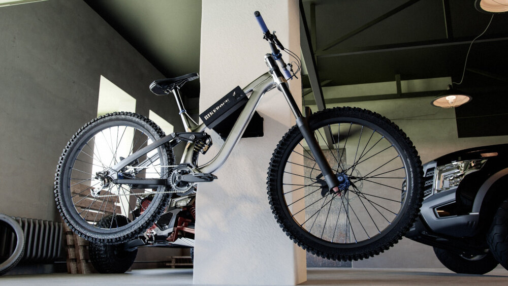 Rower zawieszony na wieszaku przymocowanym do kolumny w garażu. Na ramie roweru widoczny jest napis \'BIKEROCK\'.