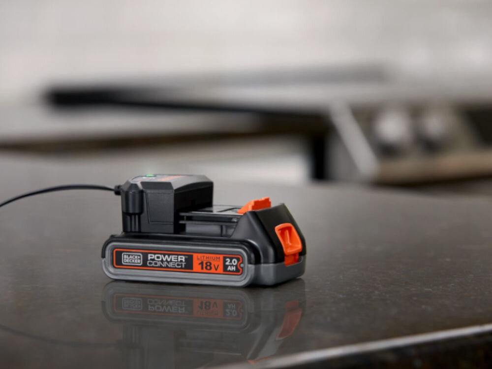 Akumulator BLACK&DECKER BL2018-XJ 2Ah 18V, ładowanie, praca, zamontowanie, pamięć, waga, Akumulator leży na blacie w kuchni z podpiętą ładowarką do niego