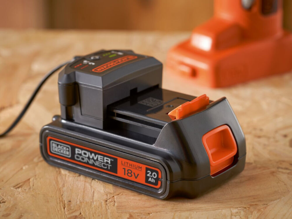 Akumulator BLACK&DECKER BL2018-XJ 2Ah 18V, Rozładowanie, przerwa, solidne, obudowa, Akumulator leży na blacie z płyty osb w warsztacie, podpięty pod port ładujący