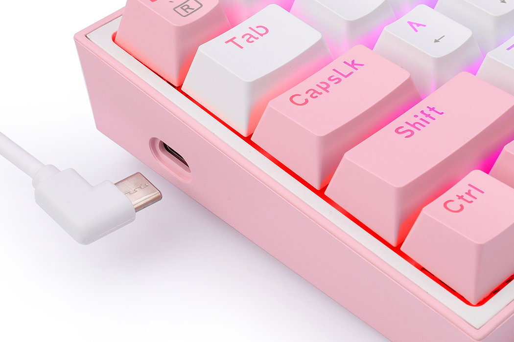 Fragment klawiatury w kolorach biało-różowych z widocznymi klawiszami: Tab, CapsLk, Shift, Ctrl. Obok klawiatury znajduje się biały kabel z wtyczką USB-C.