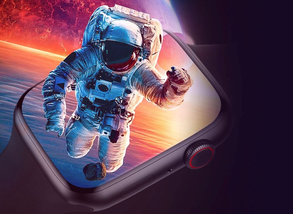 Obraz przedstawia smartwatch z wyświetlaczem, na którym widoczny jest astronauta w przestrzeni kosmicznej. Tło ekranu jest kolorowe, z dominującymi odcieniami czerwieni i fioletu.