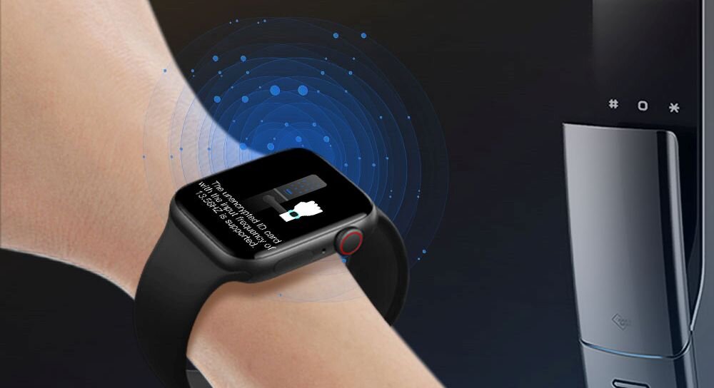 Na zdjęciu widoczny jest czarny smartwatch na nadgarstku, z wyświetlaczem pokazującym tekst: \'The user needs to enter the password on the lock to use the watch\'. W tle znajduje się nowoczesny zamek elektroniczny z kilkoma przyciskami i symbolem karty zbliżeniowej.
